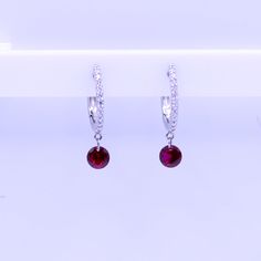 Our new drilled ruby earrings, set in 18K gold pave diamond hoops. The gemstones are drilled with a laser so they hang invisibly without a setting. To be worn casual or dress it up as primary piercing, second, or multiple position earrings. Our latest timeless trend that our customers love for themselves or as special gifts for a friend or loved one. Also available in Emerald, pink sapphire, blue sapphire, and ruby 18K gold (yellow, rose, or white) .25 ct Rubies 1.80 grams gold Made in Italy Complementary gift wrapping included