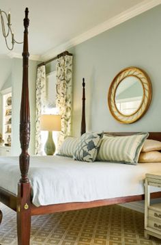 a bedroom with blue walls and white bedding