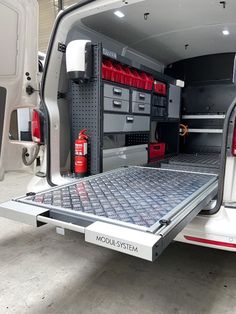 the back end of a white van with its cargo door open and tools in it