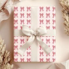 a present wrapped in pink and white paper with a bow