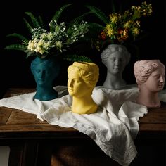 three vases with flowers in them are sitting on a table next to each other