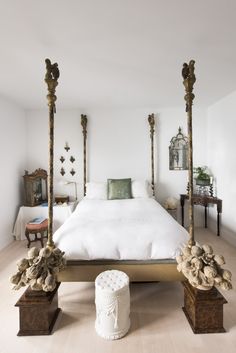 a white bed with four posts in a room