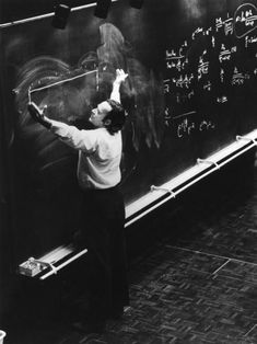 a man writing on a blackboard with chalk