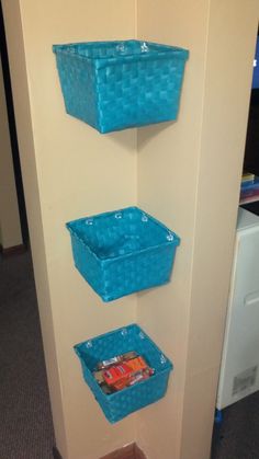 three blue baskets are hanging on the wall next to each other and one is empty