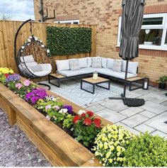 an outdoor living area with couches and flowers