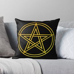 a black and yellow throw pillow with a pentagramil in the center on it