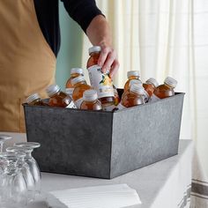 a person is pouring some drinks into a metal container