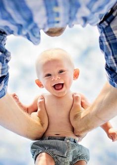 a man holding a baby in the air