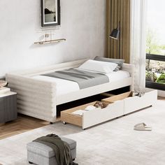 a bed with drawers underneath it in a room