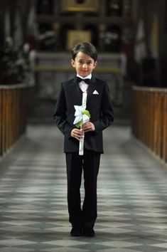 a young boy in a tuxedo and bow tie