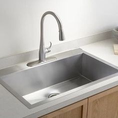 a kitchen sink with a faucet in the middle and a counter top below it