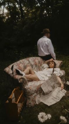 a woman laying on top of a couch next to a man