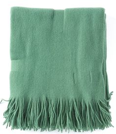 a green blanket with fringes on it