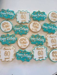 decorated cookies are arranged on a wooden table with happy 50th birthday words and numbers in blue, gold and white