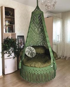 a green hammock hanging from the ceiling in a living room