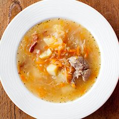 a white bowl filled with soup on top of a wooden table