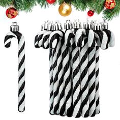 three black and white candy canes hanging from a christmas tree with ornaments around them