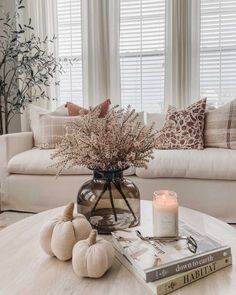 a living room filled with furniture and a table topped with a vase full of flowers