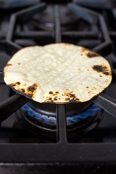 an uncooked tortilla sitting on top of a gas stove burner