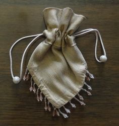 a small bag with tassels is sitting on a table