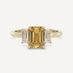 an emerald cut diamond ring with three baguets