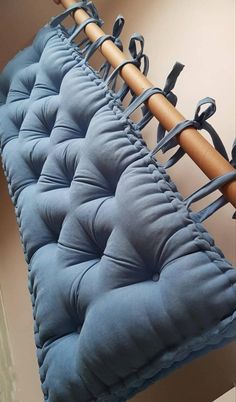 a row of blue cushions with wooden handles