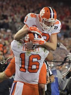 two football players hugging each other on the field