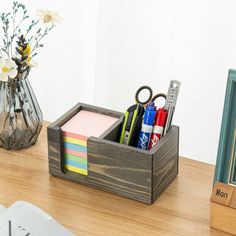 a wooden desk with pens, scissors and other office supplies