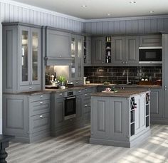 an image of a kitchen setting with grey cabinets and wood flooring on the walls