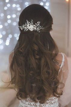 a woman wearing a wedding hair comb with flowers on it's head and long brown hair