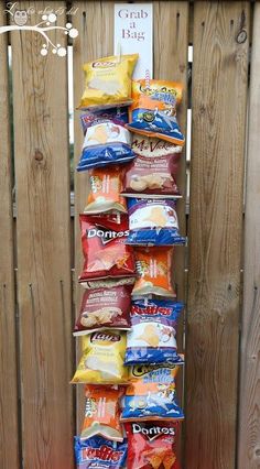 a stack of chips sitting on top of a wooden fence next to a bag of chips