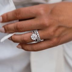 a woman's hand with two wedding rings on her left and the other hand holding a napkin