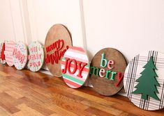 a row of wooden christmas signs sitting on top of a hard wood floor