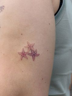 a woman's arm with two starfishs on it and one is pink