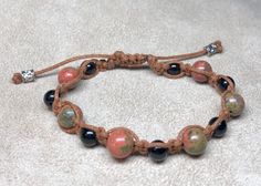 Onyx and unakite beads braided in brown cord. Adjustable 6-9 inches. Pull closed with metal cylinder beads. Casual Brown Braided Bracelets With Round Beads, Casual Brown Macrame Beaded Bracelet, Casual Braided Bracelets With Natural Stones For Healing, Adjustable Brown Braided Bracelets For Healing, Casual Braided Bracelets With Natural Stones, Casual Adjustable Braided Bracelets With Natural Stones, Cutesy Outfit, Brown Macrame, Metal Cylinder