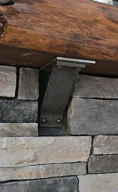 a close up of a piece of wood on top of a stone wall next to a wooden beam