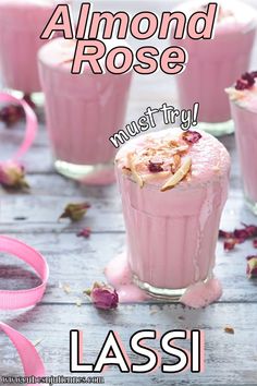 there is a pink smoothie in the glass with whipped cream and rose petals around it