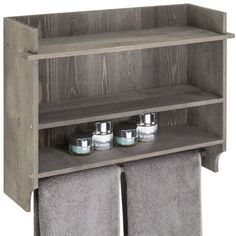 a wooden shelf with two towels and three jars on it