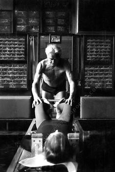 a man sitting on top of a bench next to a child in front of a chalkboard wall