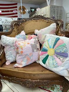 several decorative pillows are sitting on an old chair