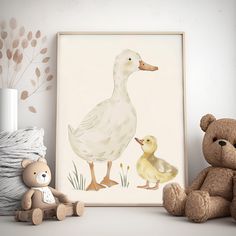 a teddy bear sitting next to a duck and duckling painting on a white wall