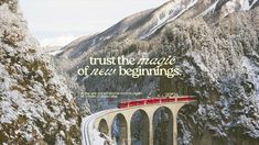 a red train traveling over a bridge in the middle of snow covered mountains and trees