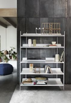 a white shelf with books and vases on it