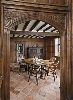 an archway leading into a dining room with wooden furniture