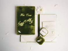 the wedding stationery is green and white, with flowers on each side of it