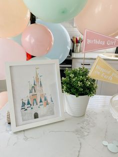 a table topped with balloons and a photo frame