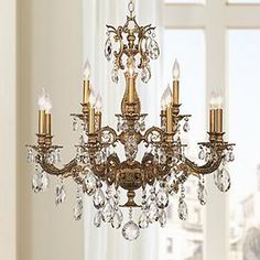 a gold chandelier with crystal drops hanging from it