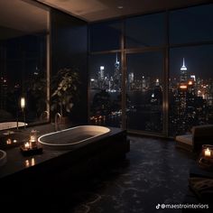 a bath tub sitting next to a large window in a room with a city view