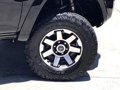 a black truck parked on top of a sidewalk