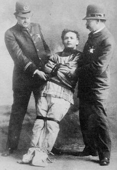 three men standing next to each other in front of a black and white photo with one holding the arm of another man